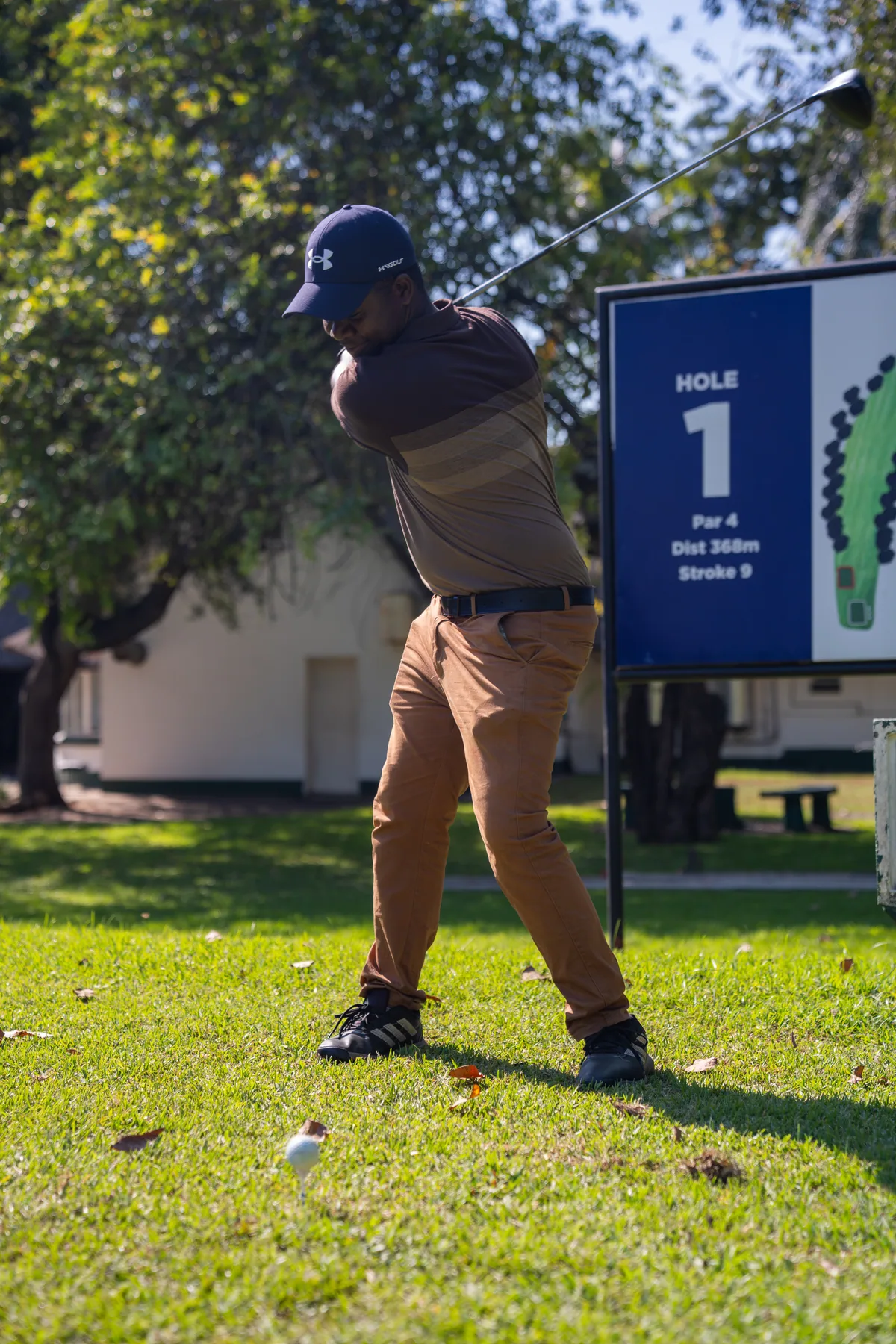 A golfer teeing off at the first
